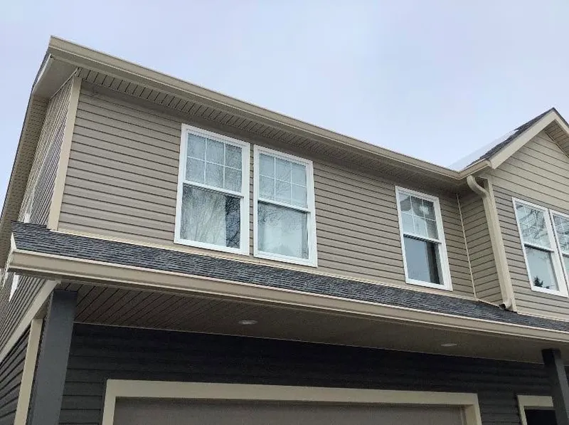 Crew carrying soffit and fascia materials along a home